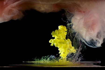 liquid multi-colored paint mixed moving in waterの写真素材