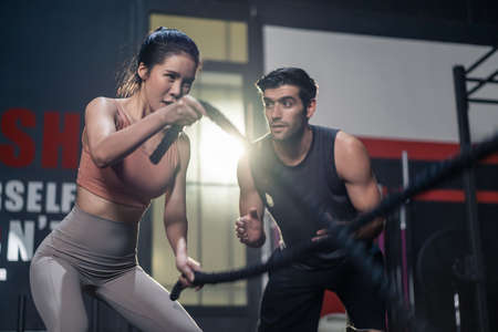 Caucasian Fitness trainer or instructor instruct and motivate young active beautiful sport girl...