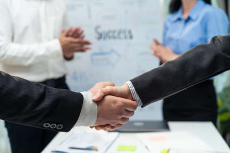 Close up hands of business people handshake after success negotiations. Employee worker team clap hand and enjoy partnership agreement, Business deal merger and acquisitionto in company meeting room.の写真素材