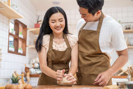 Asian new marriage couple stay home, spend time together in kitchen. Romance Young attractive...
