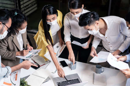 Group of Asian team business people working in office with new normal social distancing lifestyle...