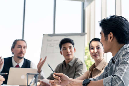 Asian man and team working brainstorm to solve problem and presentation new idea. People discuss and smile on new challenge topic in meeting room. Business finance and communication planning concept.の写真素材