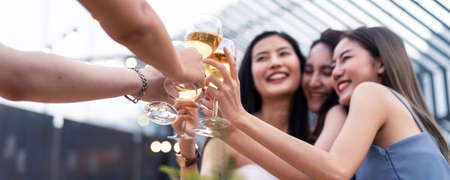 Group of young cute Asian girl gang best friends having party at rooftop restaurant. Girls drinking beer alcohol and toasting glass feeling happy enjoy, fun with smile face. Night lifestyle concept.の写真素材