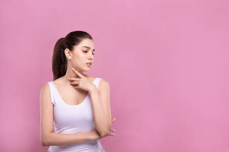 Beautiful Young Mix Asian Caucasian woman with clean fresh white skin touching face with fingers softly in beauty pose. Facial treatment, cosmetic, spa, make up and surgery advertisement.の写真素材