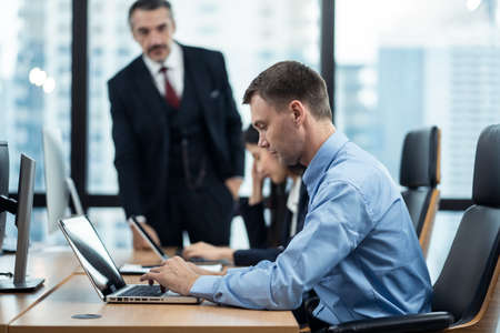 Group of diversity people working in office, two caucasian man and asian woman sitting on desk...