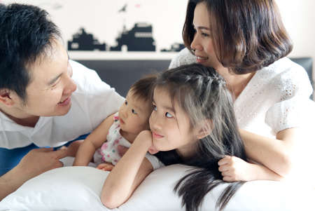 Happy family activity portrait concept. Asian mother and little two daughters looking at father with...