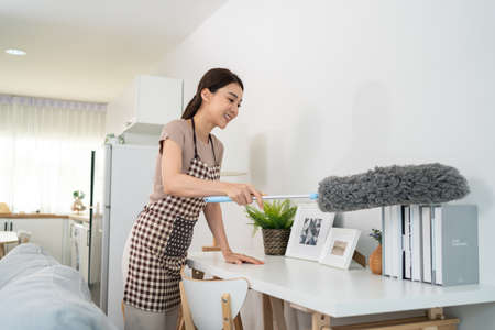 Asian cleaning service woman worker cleaning in living room at home. Beautiful young girl...