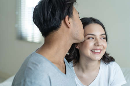 Asian attractive couple sitting together after wakeup in the morning. Young new marriage man and...