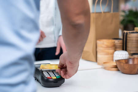 Close up hands of young man use credit card pay for vase goods order. Attractive male customer...