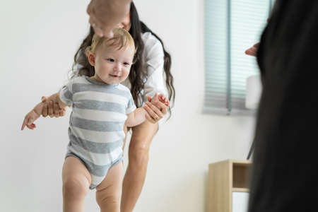 Asian young couple having dinner to celebrate valentine's day together. Attractive romantic new marriage man and woman having night party eat foods on table for wedding anniversary in kitchen at home.の写真素材