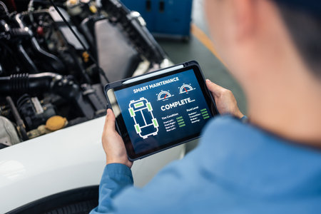 Close up of Automotive mechanic running diagnostics software on tablet. Asian young vehicle service...