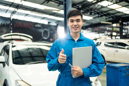 Portrait of Asian handsome automotive mechanic men standing in garage.Vehicle service manager worker...