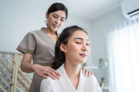Asian young happy woman feeling relax during shoulder and back massage. Attractive beautiful girl...