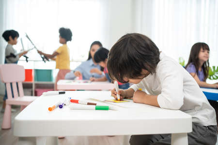 Asian beautiful young woman teacher teaching art to kids at school. Attractive Instructor master female explain and educate draw and painting, palying with student kindergarten preの写真素材
