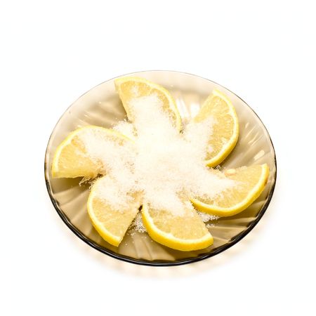 Lemon slices and sugar on plate isolated on whiteの写真素材