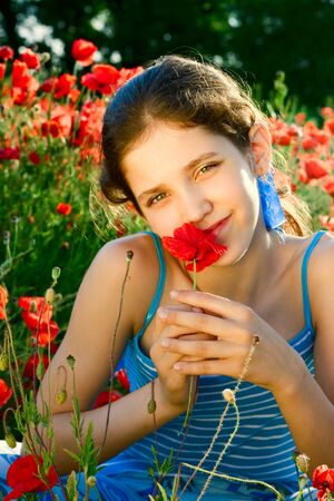 Portrait teen girl with poppy on natureの写真素材