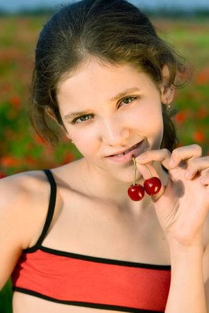 Portrait teen girl with cherry on natureの写真素材