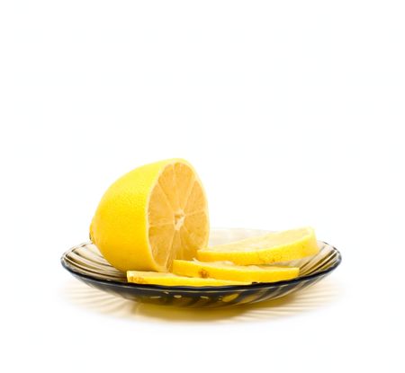 Lemon and lemon slices on plate isolated on whiteの写真素材