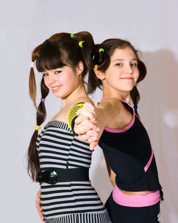 Two fun teen girls on grey backgroundの写真素材