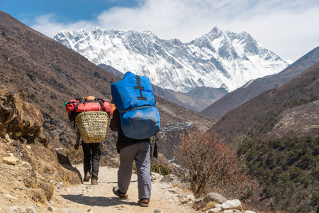 Porter carrying heavy loads walk to Everest base camp, Himalaya mountain, Nepal, Asiaの写真素材