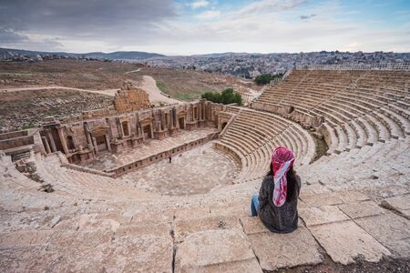 A woman sit on top of Roman theater in Jerash ruin and ancient city, Jordan, Arab, Asiaの写真素材