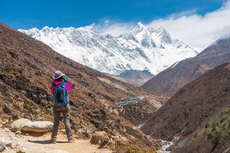 A trekker taking picture while trekking in Everest Base Camp, Himalaya mountains range in Nepal, Asiaの写真素材