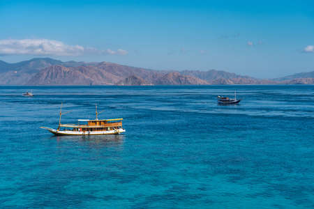 Crystal clear water and tourist boats around Flores island national park in summer season, Indonesia, Asiaの写真素材