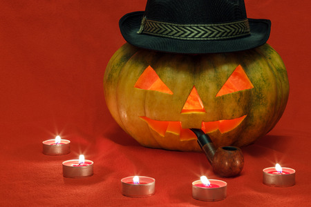 Pumpkin for Halloween with glowing eyes and smoking pipeの写真素材