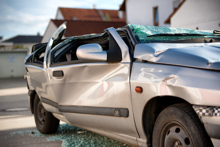 Totally destroyed silver sedan motor car in a traffic accident with a flattened roof, shattered windows and crumpled bodyworkのeditorial素材