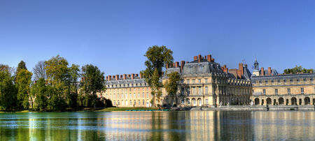 View of the Chateau de Fontainbleu and its reflection across a tranquil lake, situated close to Paris it introduced the Mannerist style of architecture to France and is the largest royal chateauのeditorial素材