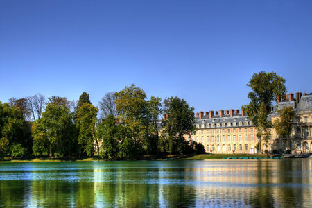 View of the Chateau de Fontainebleau and its reflection across a tranquil lake, situated close to Paris it introduced the Mannerist style of architecture to France and is the largest royal chateauのeditorial素材
