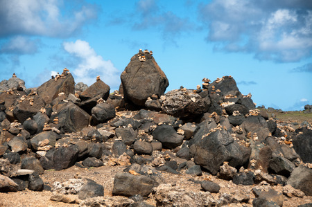 Stone pebbles stacked on the rocks on the beach in Aruba in a simple artistic statement of beaty in nature, zen and meditation under a sunny blue tropical summer skyの写真素材