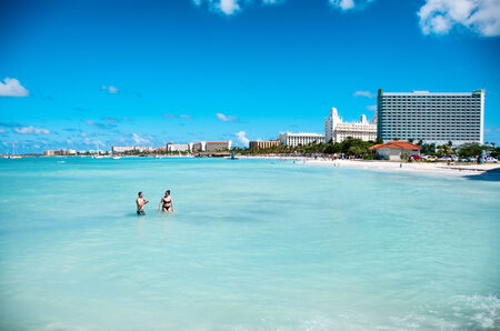 Scenic view across a calm blue ocean along the coastline of hotels and tourist accommodation at the resorts at Palm Beach on Aruba in the Caribbeanのeditorial素材