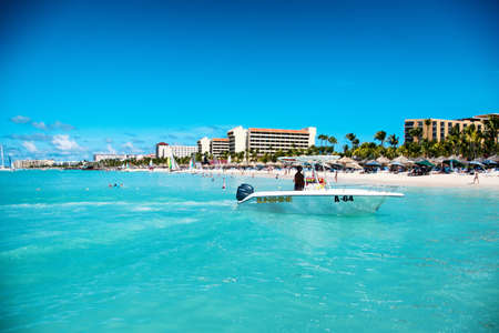 Scenic view across a calm blue ocean along the coastline of hotels and tourist accommodation at the resorts at Palm Beach on Aruba in the Caribbeanのeditorial素材