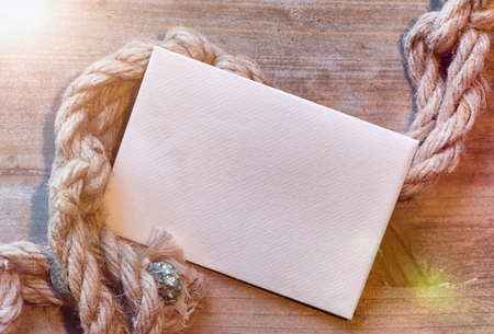 Nautical maritime background with cordage on weathered wood with blank white card and copyspaceの写真素材