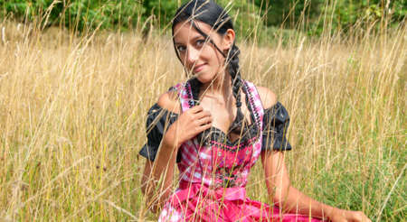 Young woman wearing dirndl posing in the fieldの写真素材