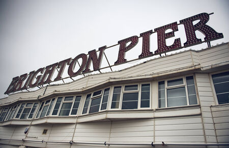 Brighton Pier sign on the rooftop of an old wooden Victorian building on the Grade 1 listed Palace Pier in Brighton, East Sussex, UKのeditorial素材