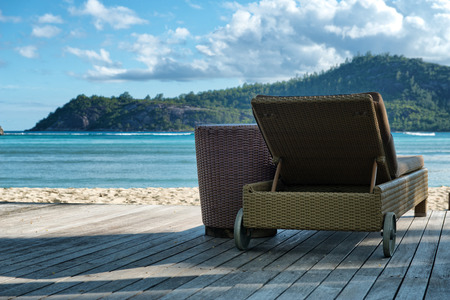 Luxury Lounge Chair on Wooden Deck Facing Beach and Mountains, Port Launay, Seychellesの写真素材