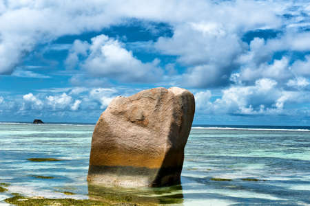 Beautiful Natural View of Close up Granite Rock on Clear Water at La Digue Island, Seychelles. Captured on Blue and White Sky Above.の写真素材