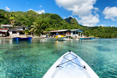 Paddling a canoe towards Port Launay island in the Seychelles and moored boats in the harbor, perspective of the rowerのeditorial素材