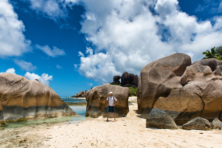 Visitor at Huge Ancient Rocks at Enchanting Anse Source d'Argent, La Digue Island, Seychelles.の写真素材