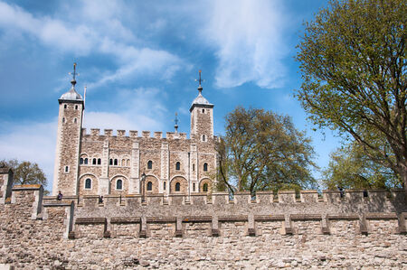 External stone facade of the iconic historical Tower of London , London , UK, a popular tourist destination and landmark against a blue skyのeditorial素材