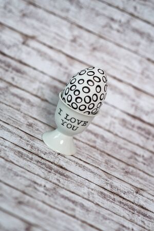 Close up Printed White Egg in a White Porcelain Cup with I Love You Texts Placed on Top of a Table