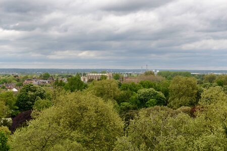 View of the town and college at Eton from Windsor Castle over woodland and parkland on a cloudy day, Berkshire, UKのeditorial素材