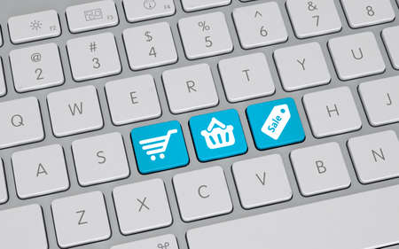 Online shopping concept with a high angle view of a white computer keyboard with three blue keys...