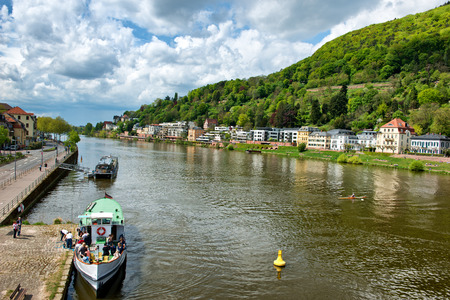 Tour Boats and Buildings on River Banks of Neckar River, Heidelberg, Baden-Wurttemberg, Germany Framed by Lush Green Hillsidesのeditorial素材