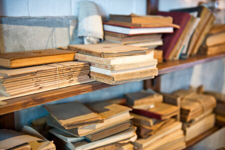 Antique Old Aged Books stacked on a wooden surfaceの写真素材