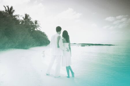 Sensual happy lovers in white clothes on the beach (Maldives). Grayscale picture with azure color accent.の写真素材