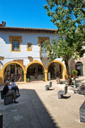 Tranquil Courtyard Plaza with Yellow Trimmed Building in Poble Espanyol Museum Area, Barcelona, Spainのeditorial素材