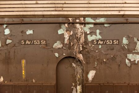 Grunge architectural background for 5th Ave and 53 street, New York, with the signboard mounted on a dingy brown wall with peeling paint, remnants of posters and a recessed archの写真素材
